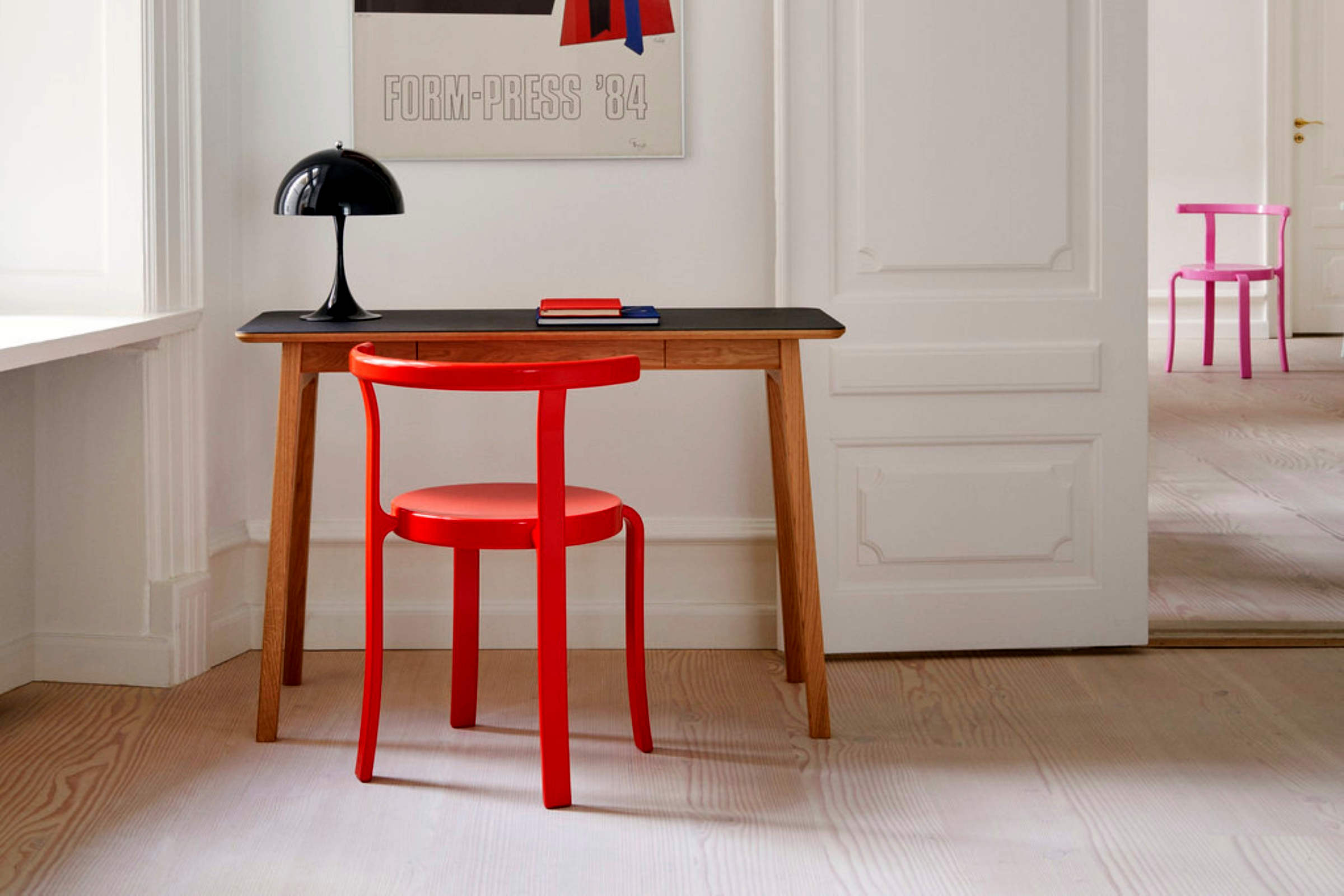 Zwei Designerstühle von Magnus Olesen mit passendem Tisch in einem modernen Raum