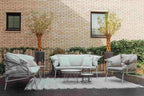 Weißes Gartensofa mit zwei Gartensesseln in einem gemütlichen Außenbereich