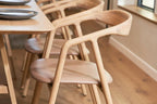 Detailansicht des BLED Designer Stuhls von Woak mit geschwungenem Holzrahmen in hellem Interieur