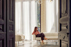 Sofa mit Person und passendem Sessel im eleganten Altbauambiente